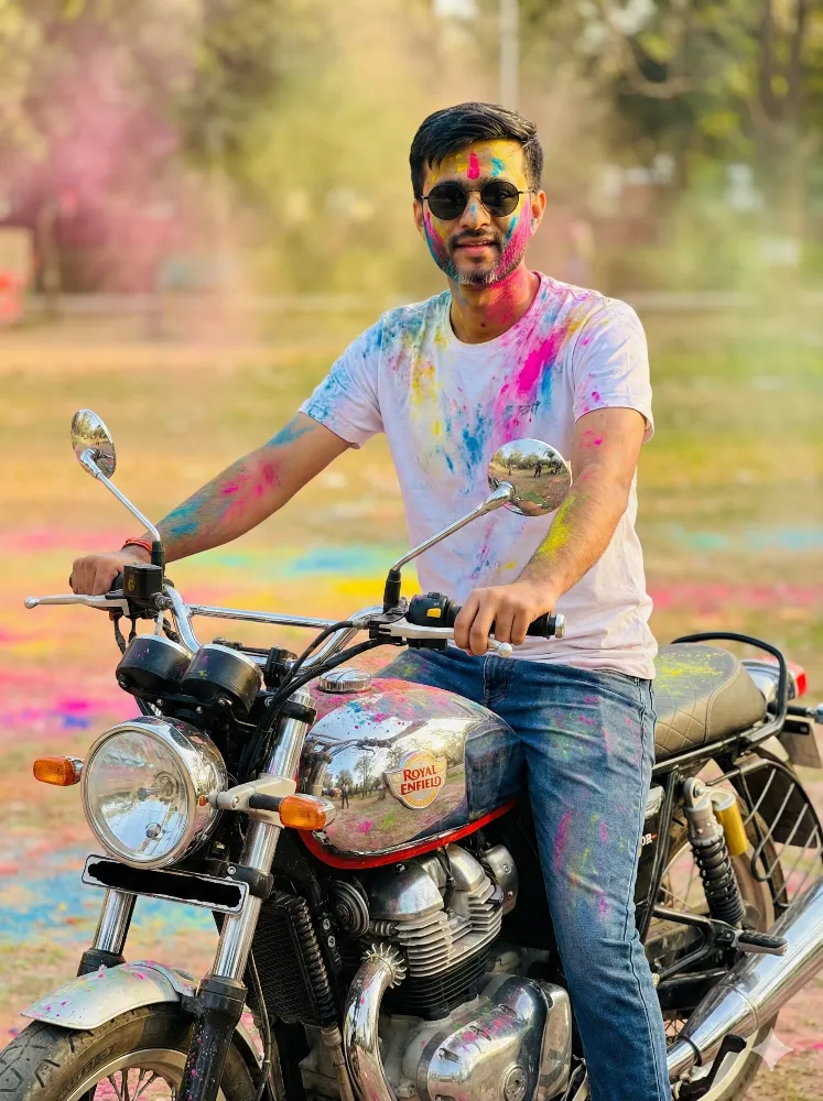 Young Man Celebrating Holi Festival on a Royal Enfield Motorcycle